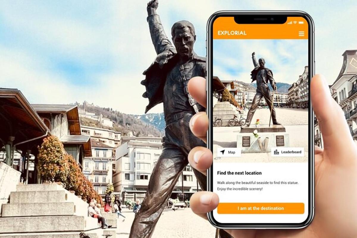 eine Person, die vor einer Statue ein Telefon hochhält