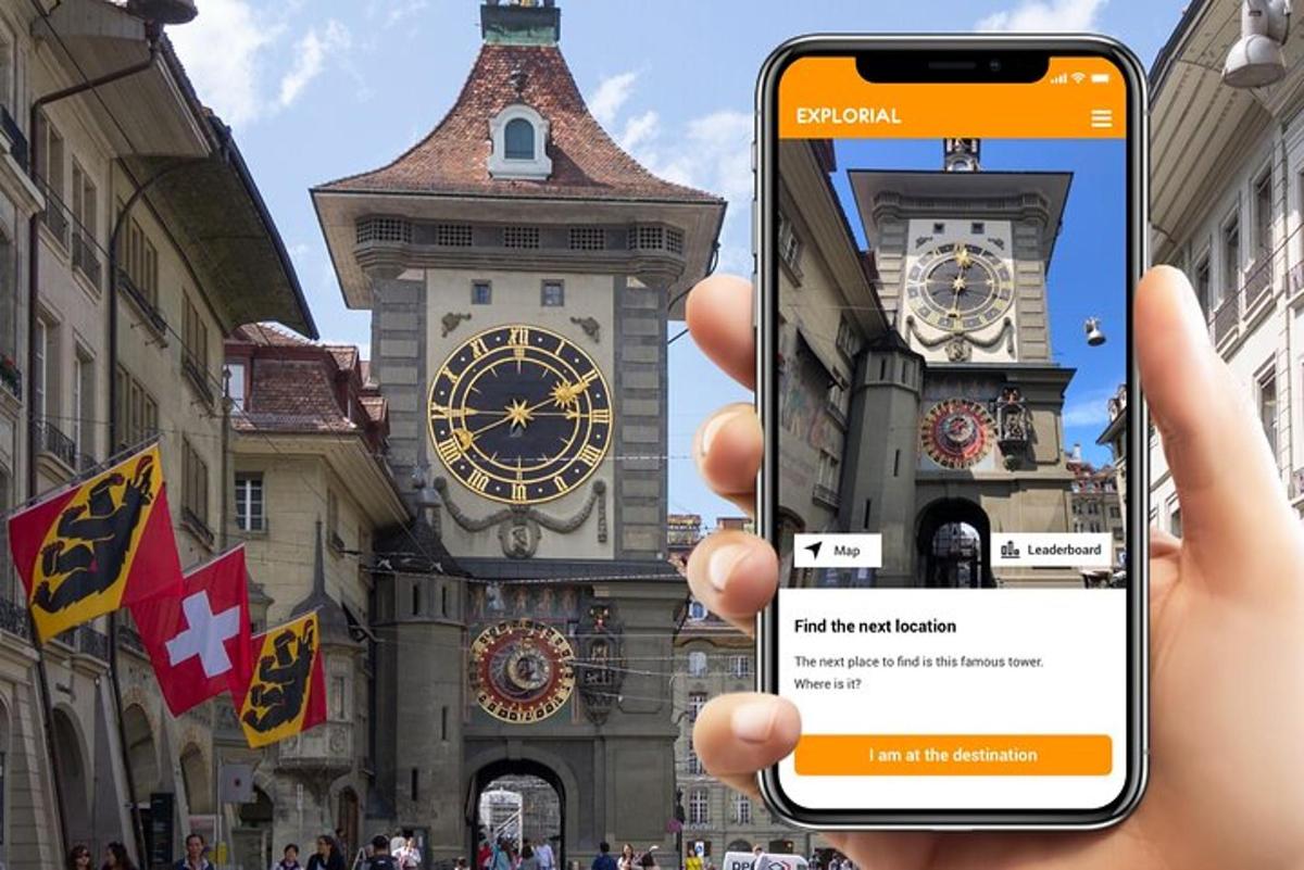 osoba držící mobilní telefon před hodinovou věží