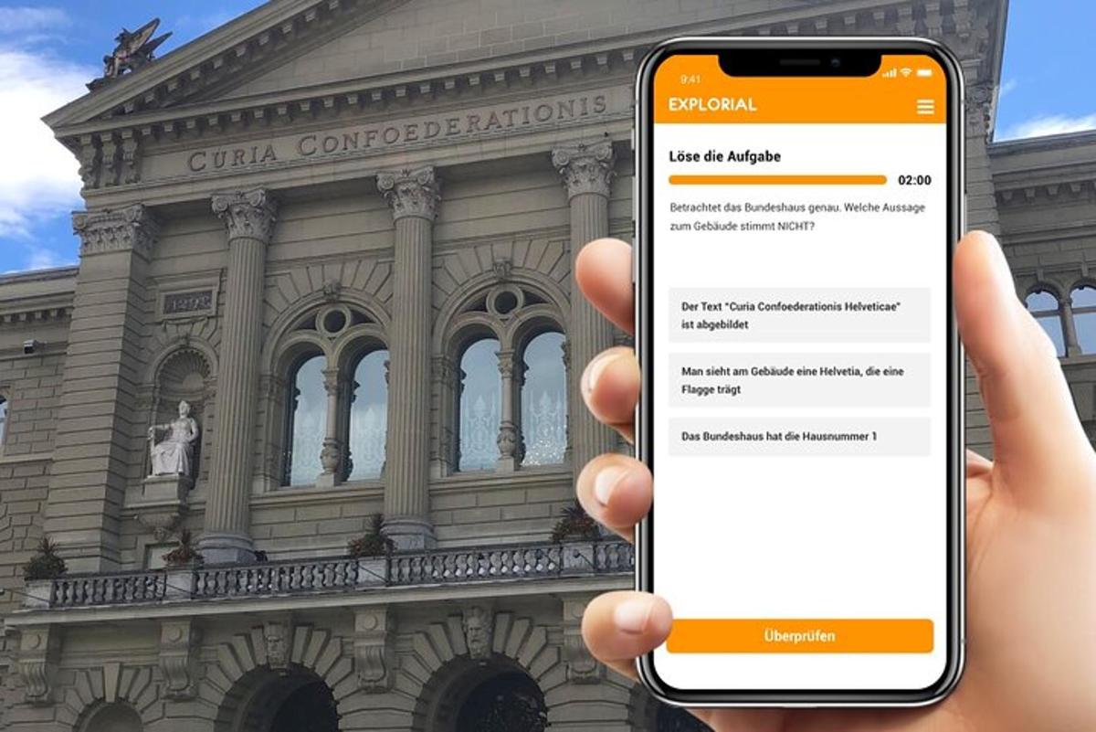 osoba držící mobilní telefon před budovou