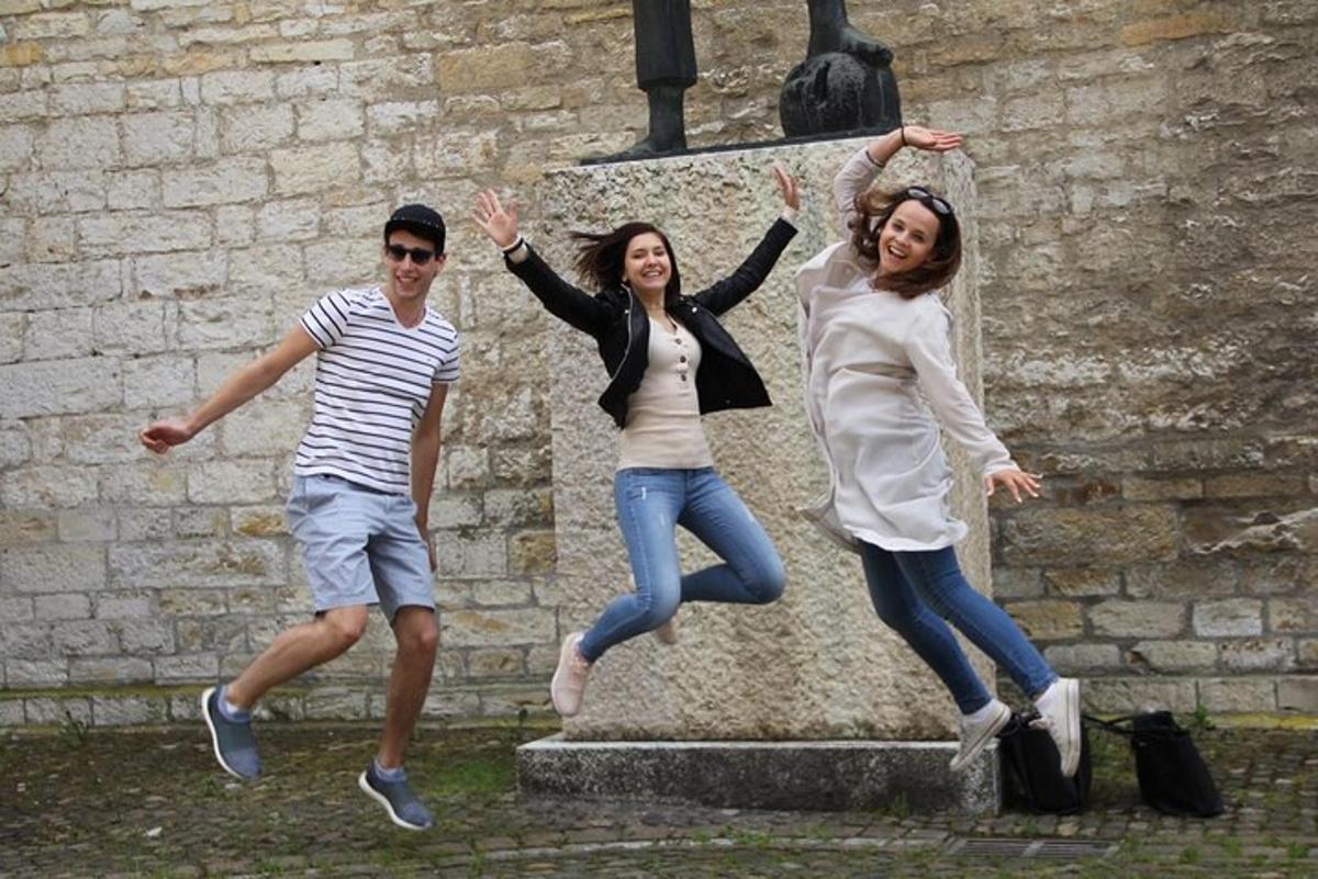 un gruppo di tre persone che saltano davanti a una statua
