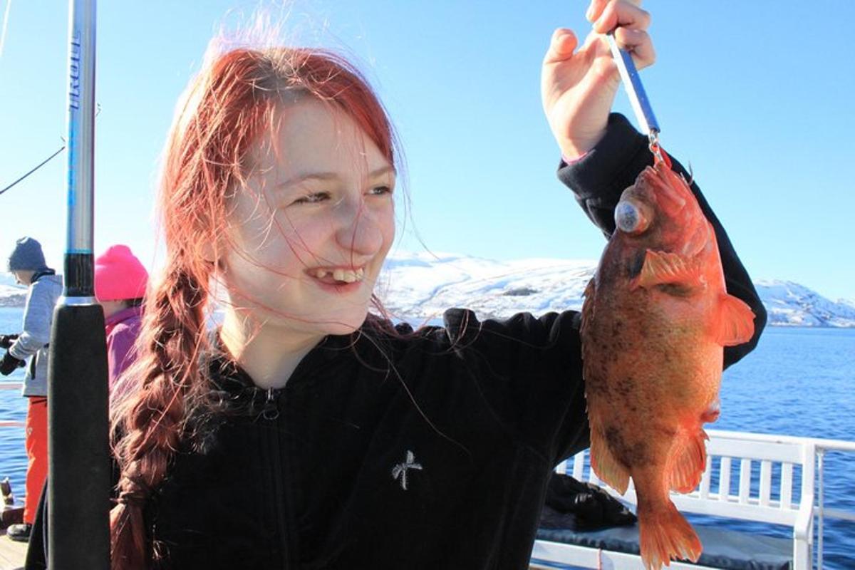 kona sem heldur á rauðum fiski á bát