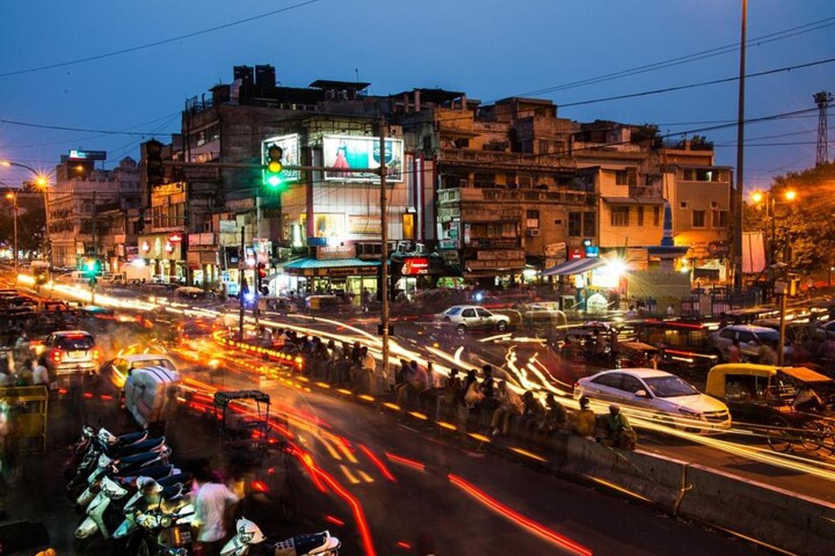 a busy city street at night with cars and motorcycles
