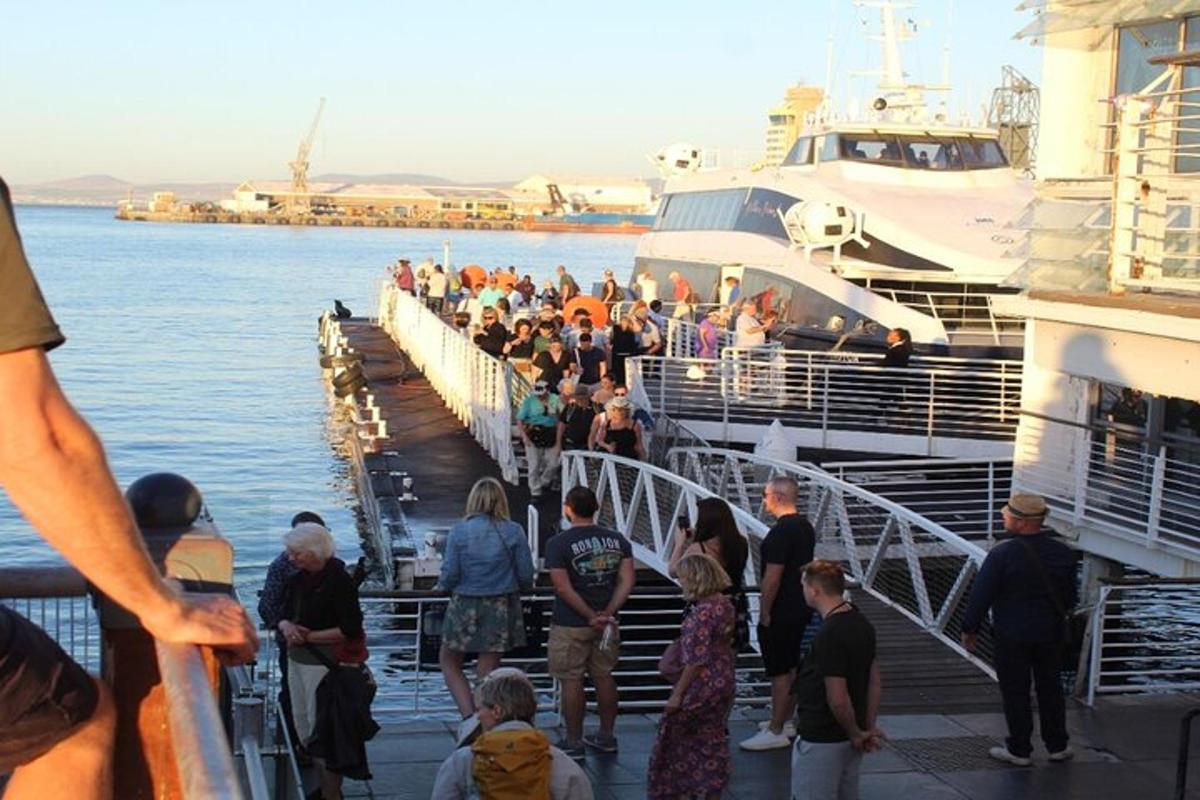un gruppo di persone in piedi su un molo accanto a una barca