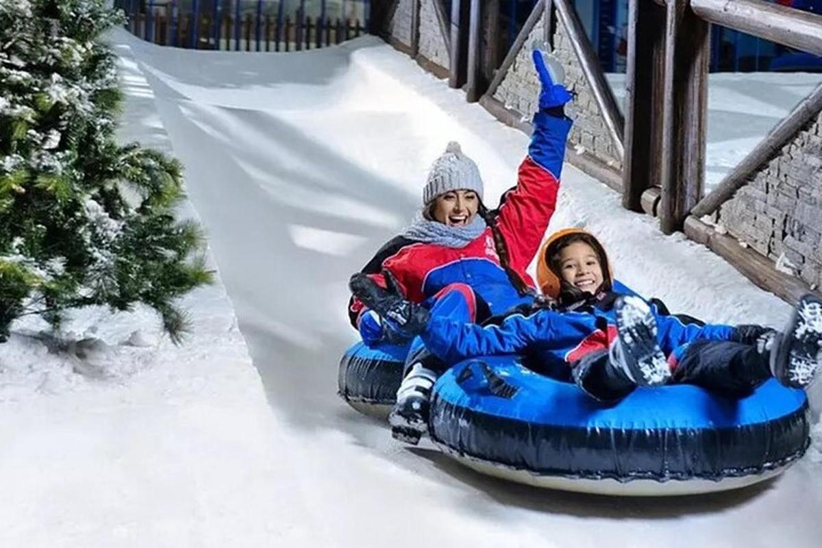 two children riding on a snowboard down a slide
