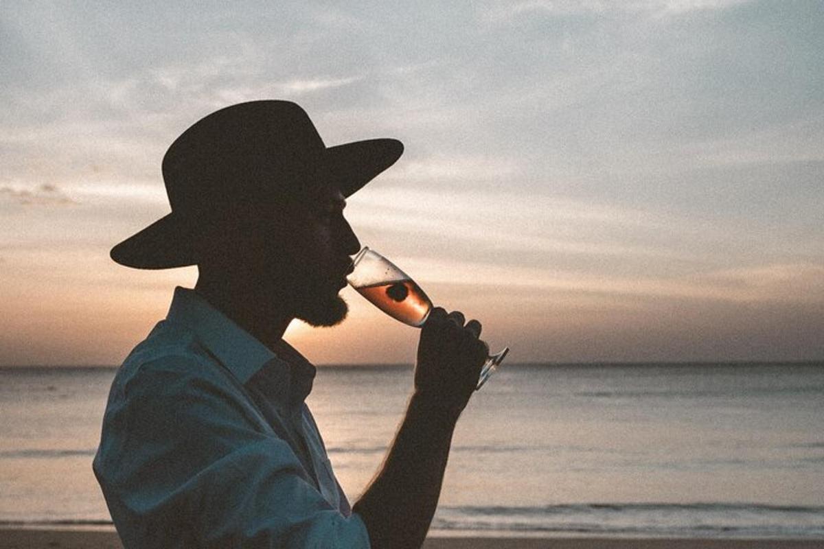 seorang lelaki memakai topi koboi minum dari gelas