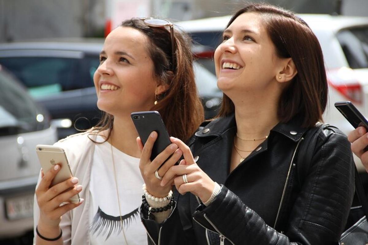 to kvinner ser på mobiltelefonene sine