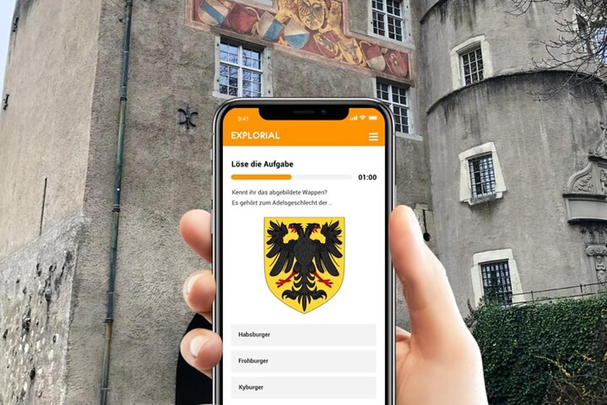 una persona che tiene in mano un telefono cellulare con uno stemma