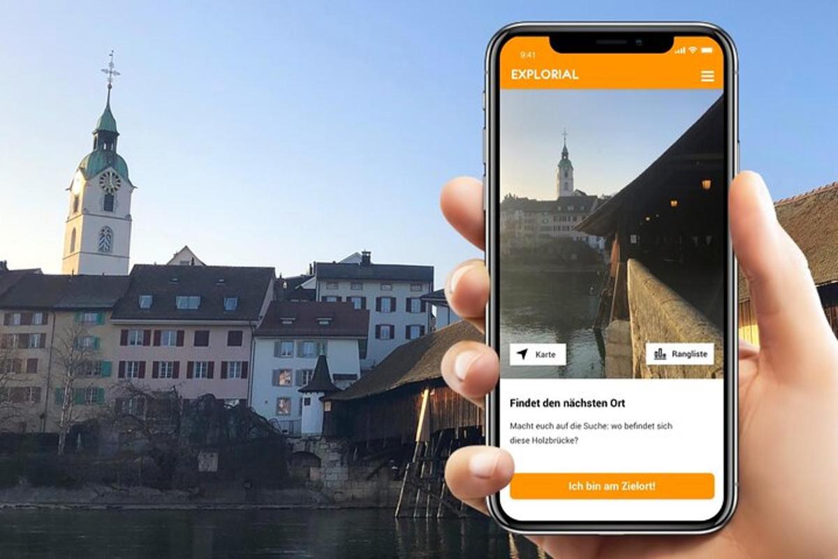 osoba držící mobilní telefon před městem