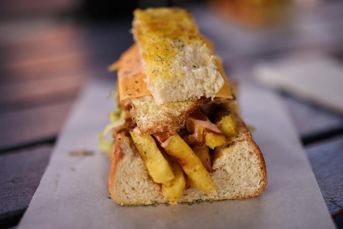 Un sándwich con queso y papas fritas en una mesa.