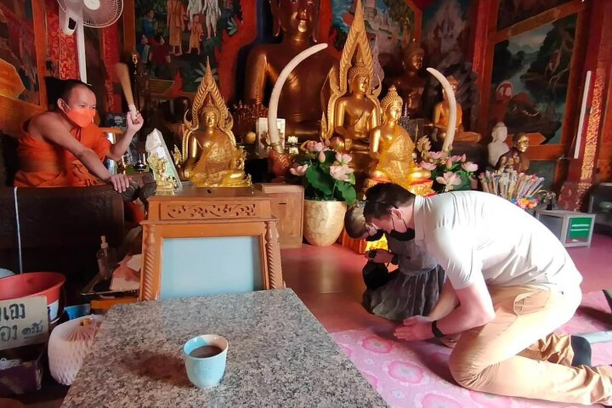 một người đàn ông đang quỳ trên sàn trong một căn phòng có bàn thờ