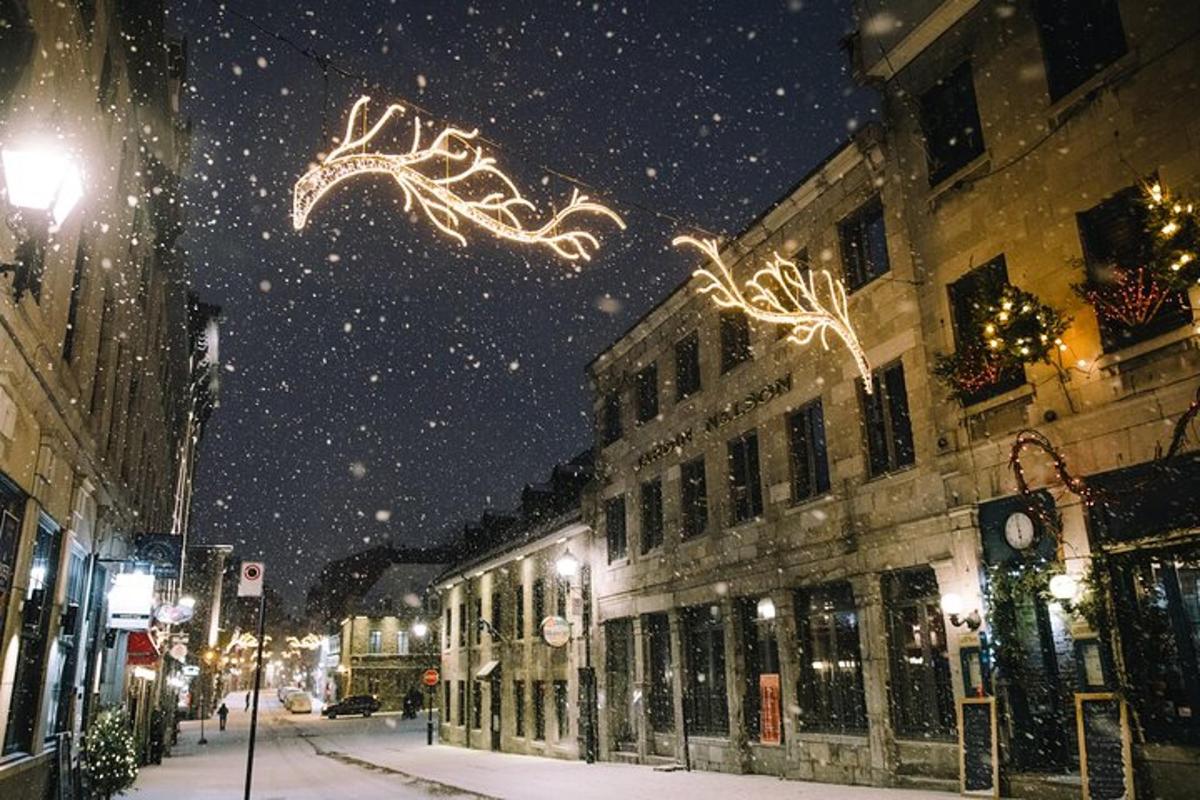 una strada cittadina con luci di Natale nella neve