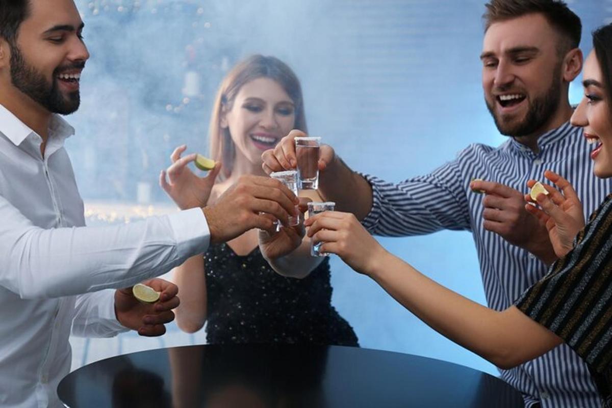 um grupo de pessoas sentadas ao redor de uma mesa com bebidas