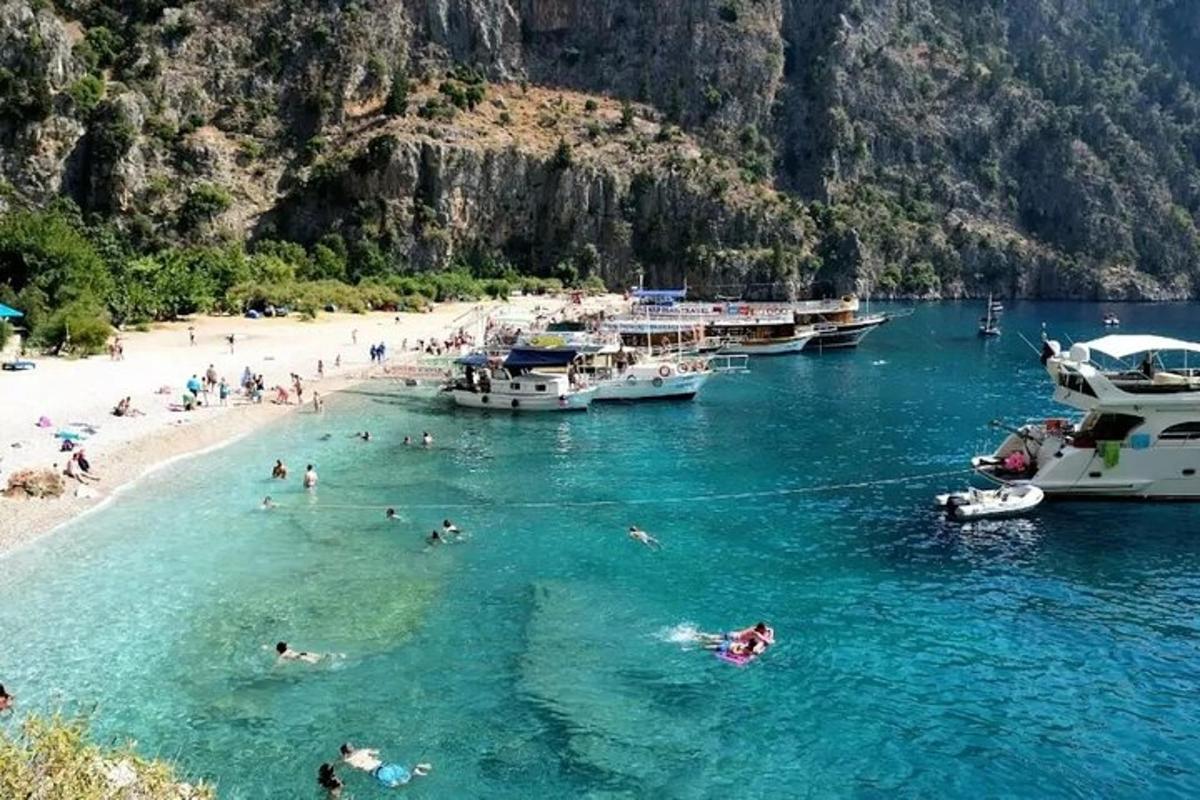people swimming in the water at a beach with boats