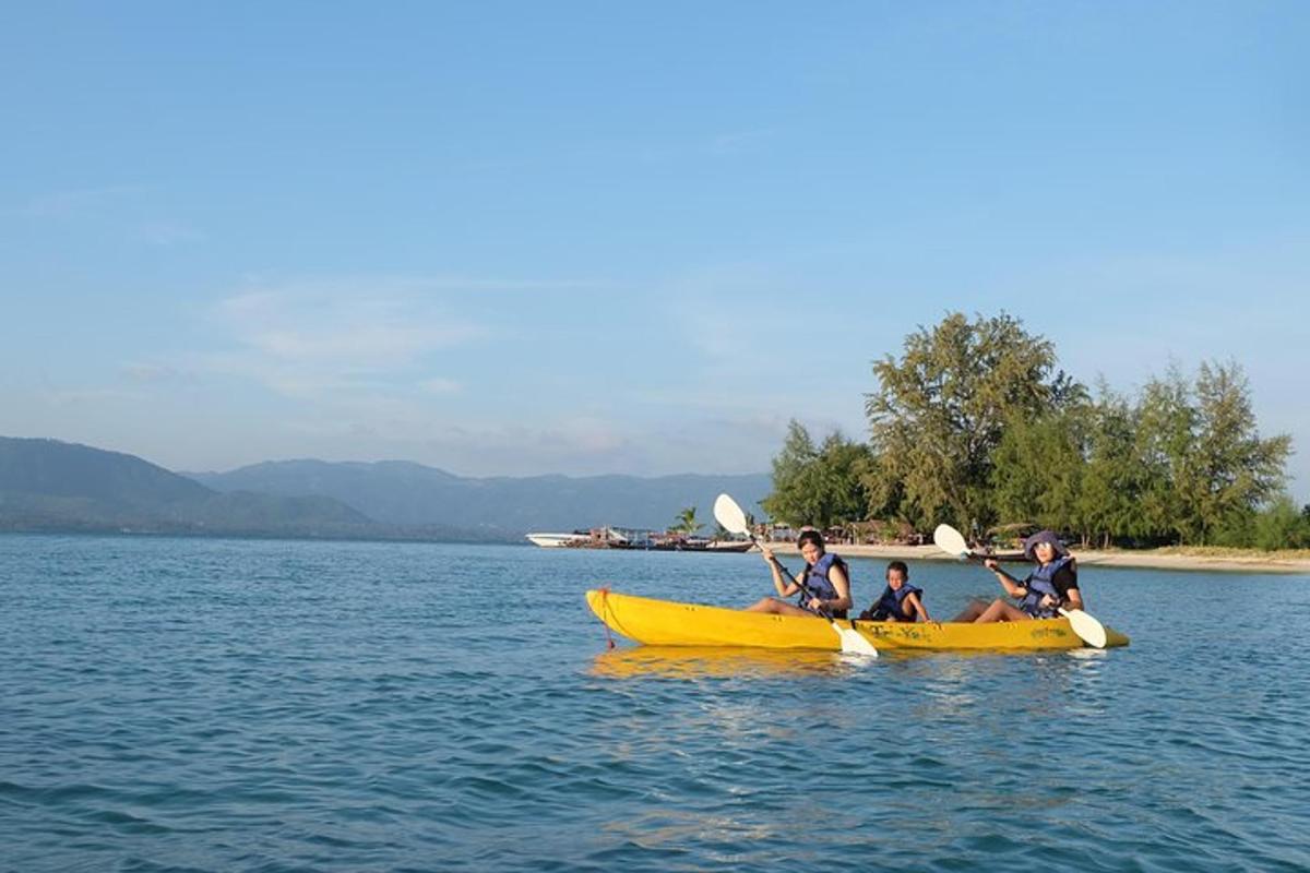 a group of people in a yellow kayak in the water