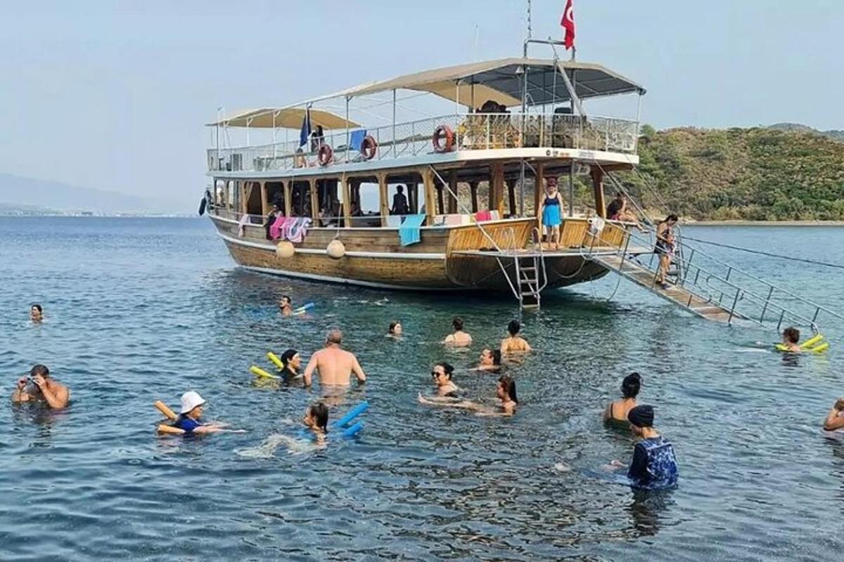 a group of people in the water in front of a boat