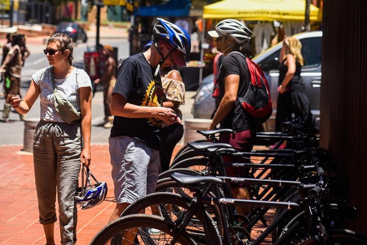 un gruppo di persone in piedi accanto a una fila di biciclette