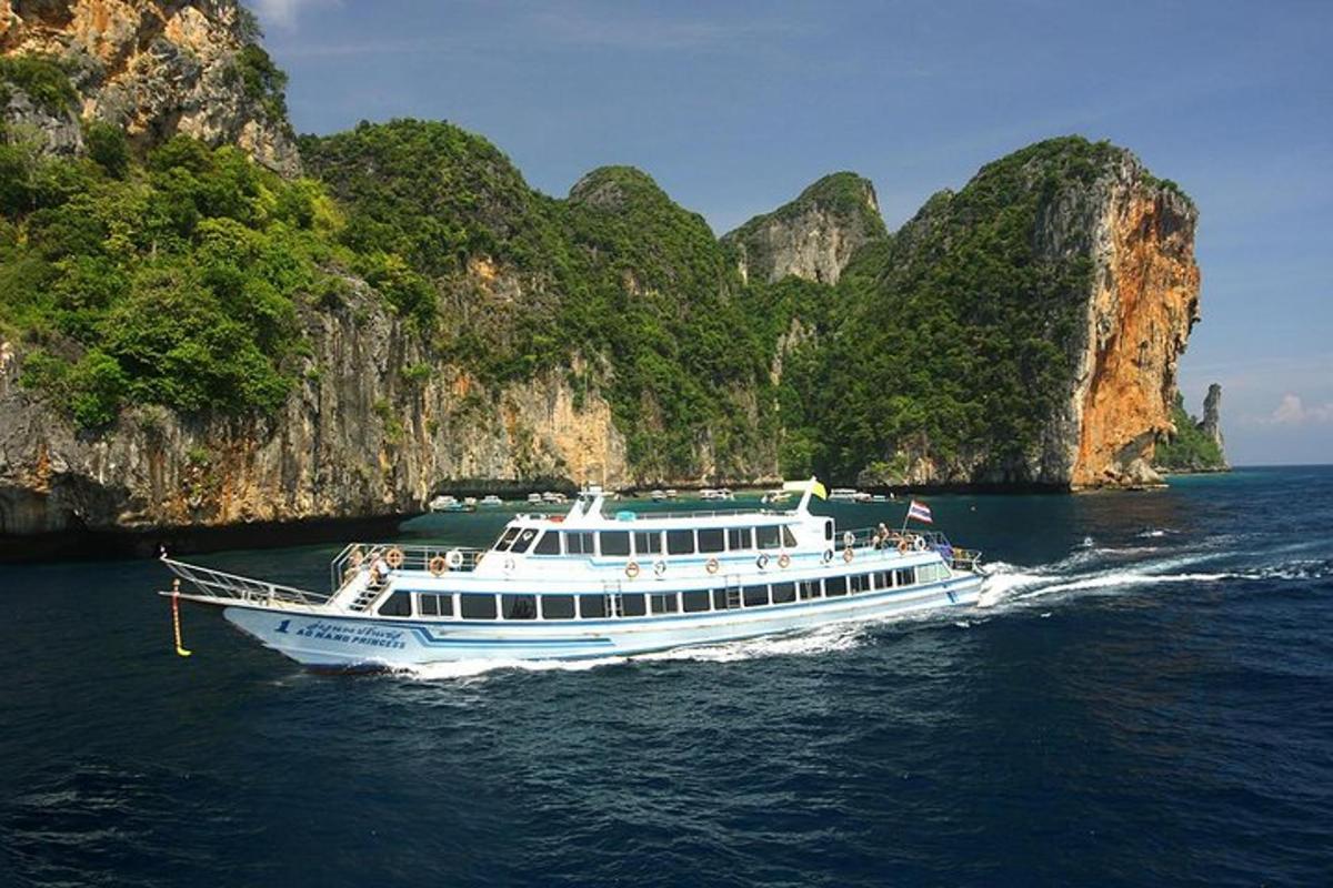 a white boat in the water near some cliffs