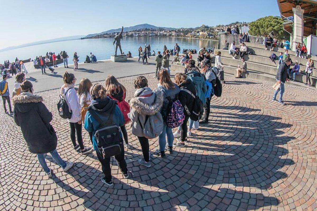 група хора, вървящи по тротоара близо до водата