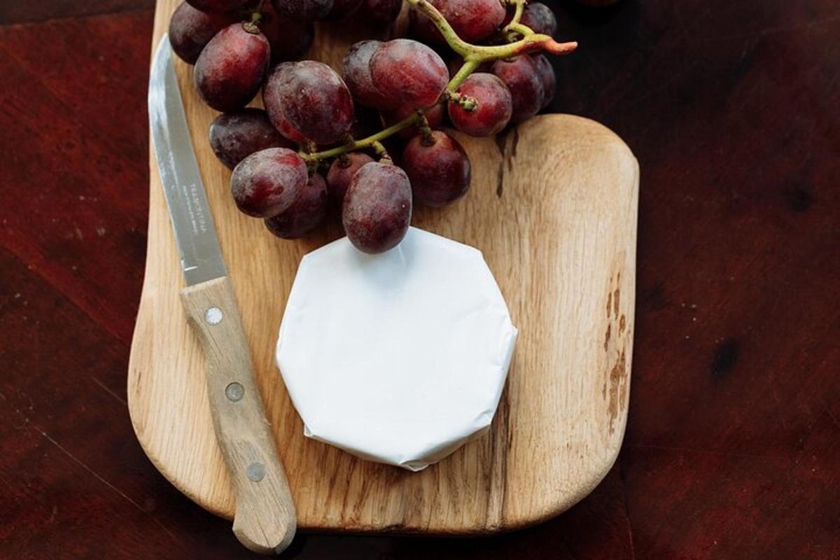 un tagliere con un grappolo d'uva e un coltello