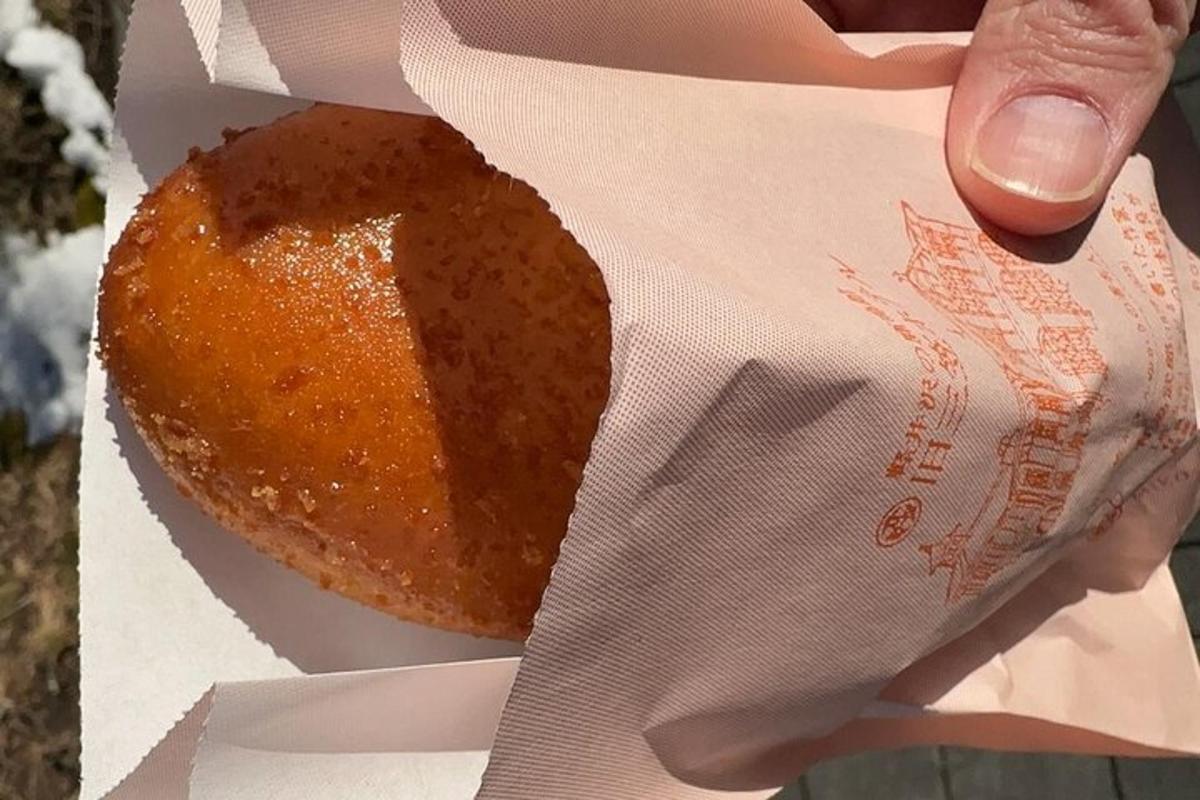 a person holding a donut in a box