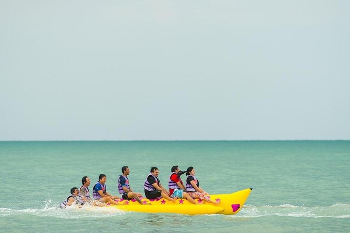 a group of people riding on a banana boat in the ocean