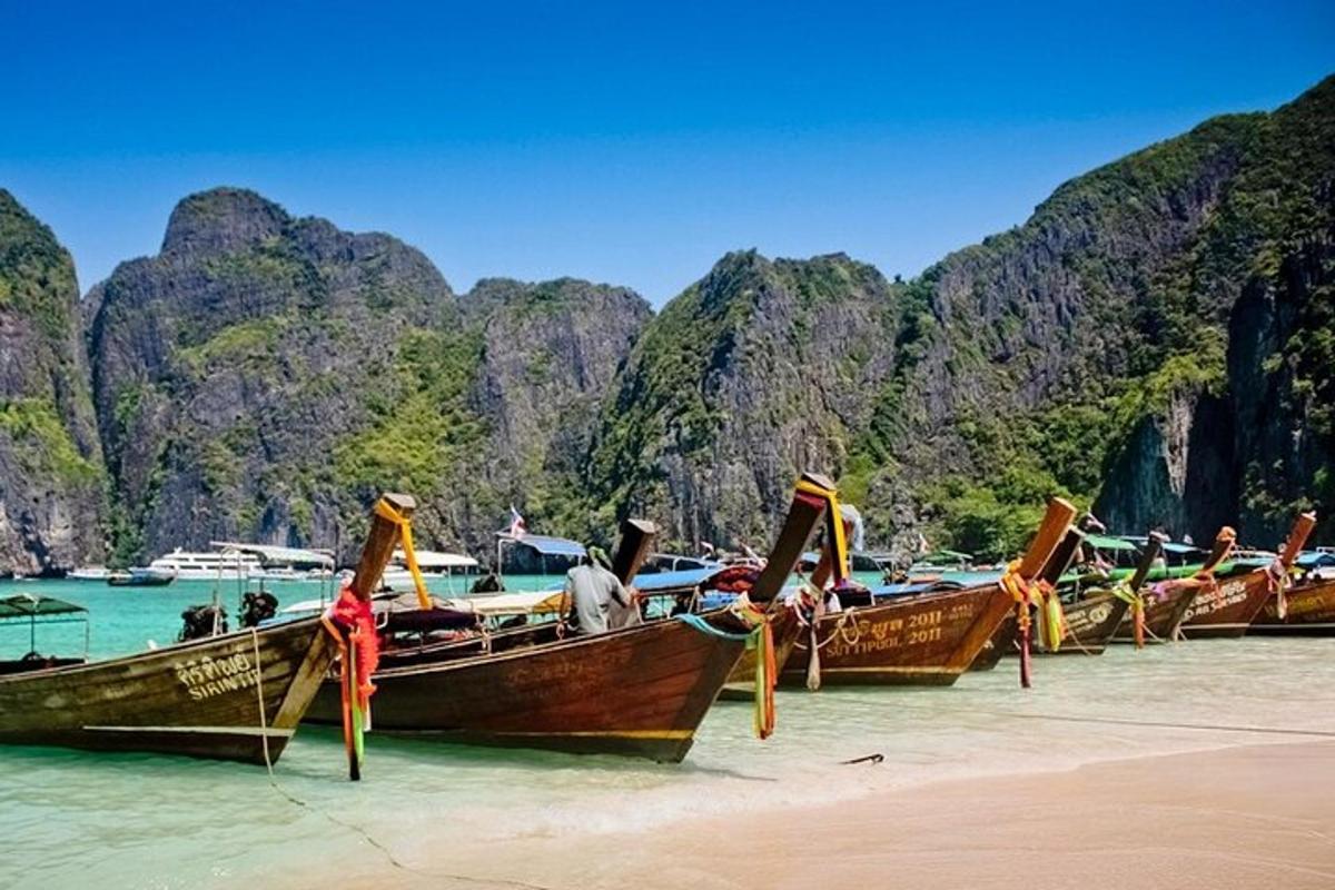 Una fila de barcos sentados en la playa en el agua.