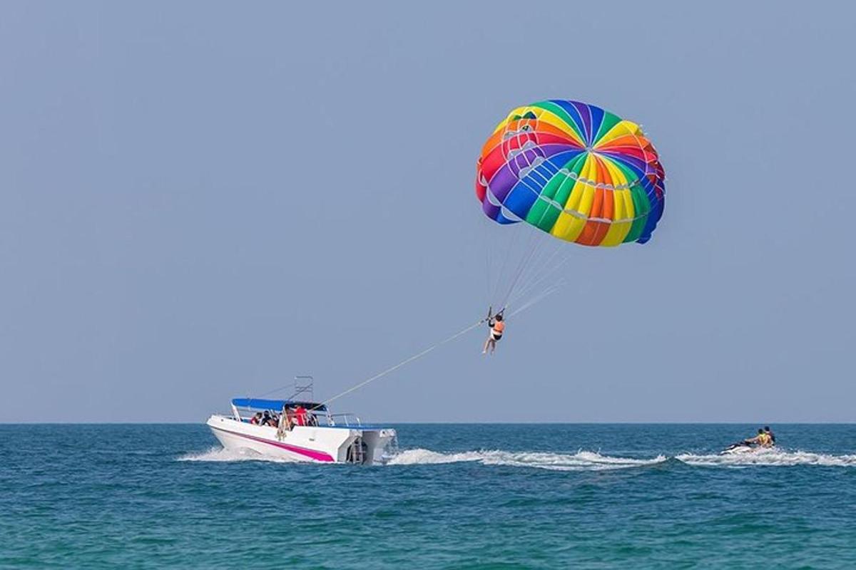 a person flying a kite over a boat in the ocean
