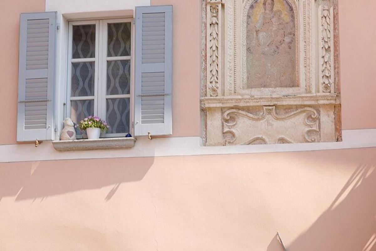 a window with blue shutters on a pink building