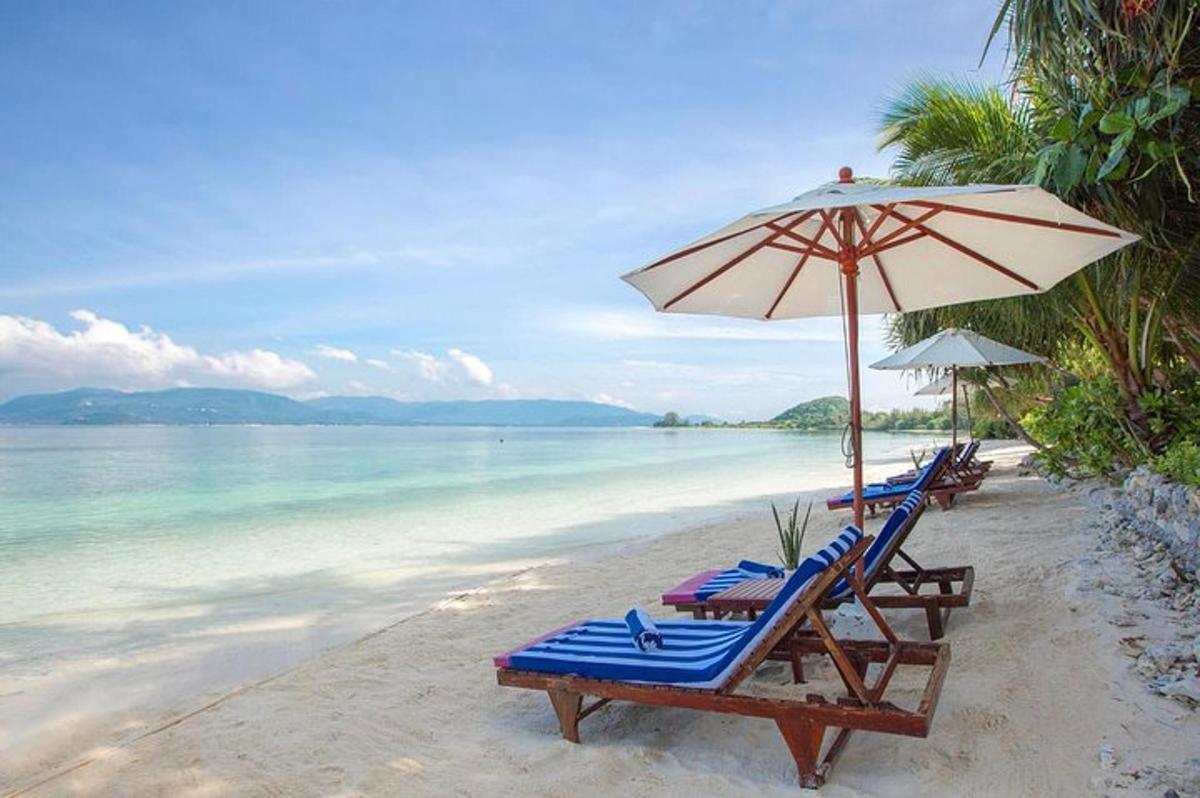 two lounge chairs and an umbrella on a beach