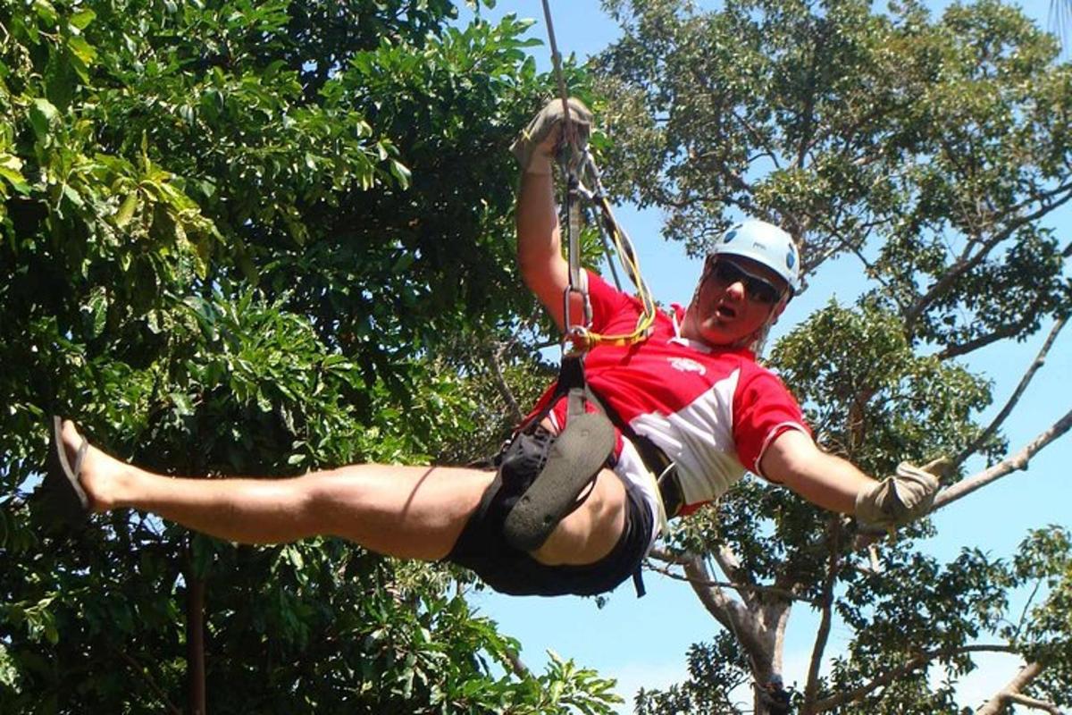 moški na ziplineu med drevesi