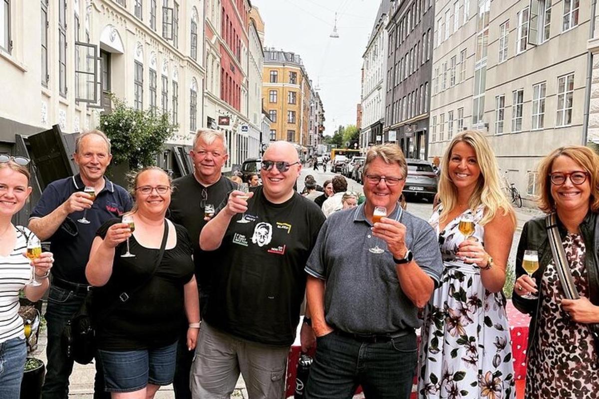skupina ljudi, ki stojijo na ulici in držijo kozarce za vino
