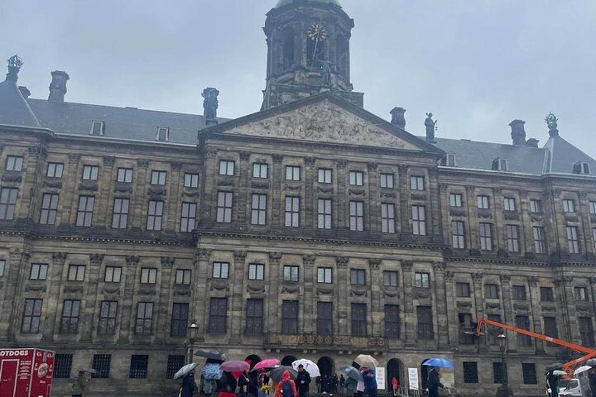 ein großes Gebäude mit Menschen mit Regenschirmen davor