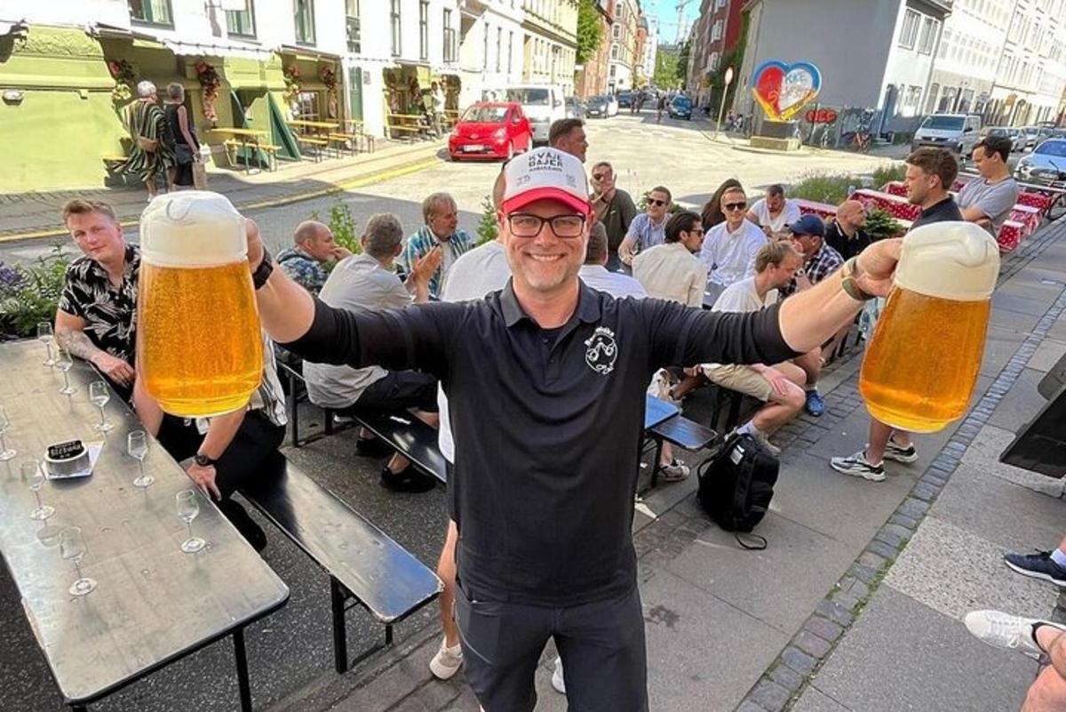 moški, ki drži dva velika kozarca piva