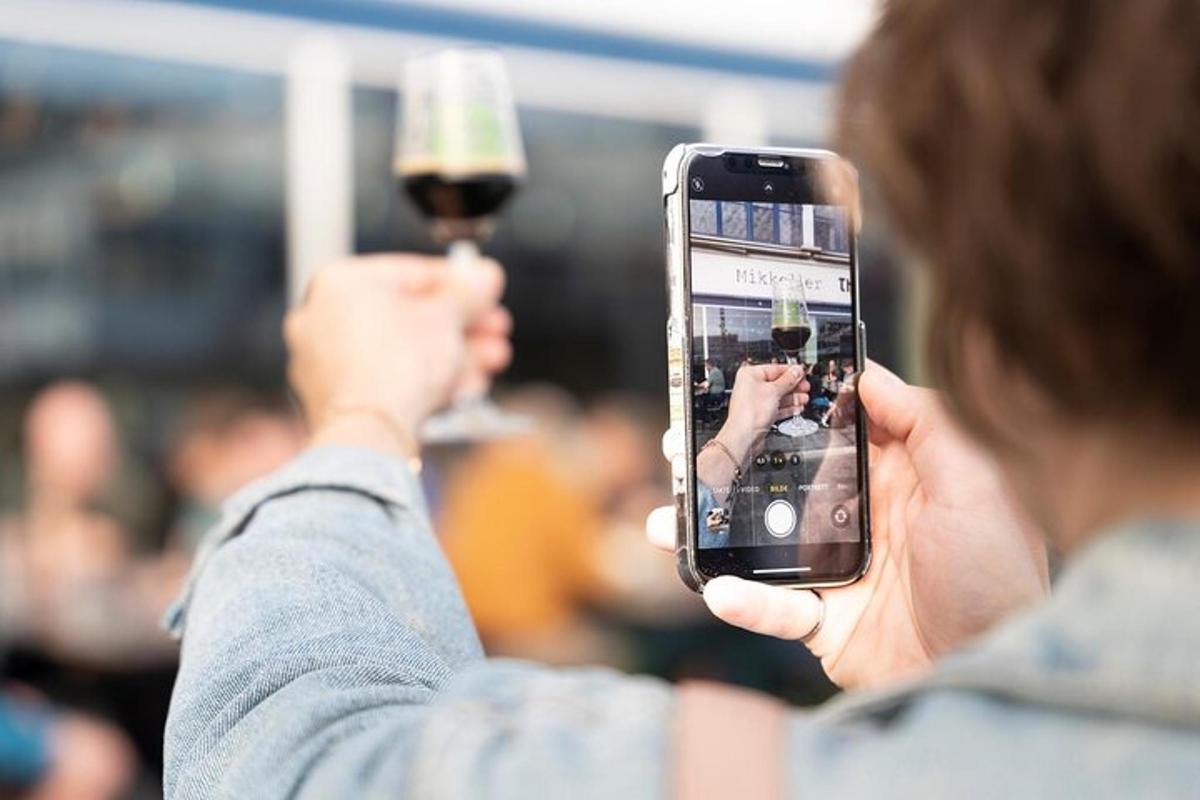 a woman taking a picture of a glass of wine