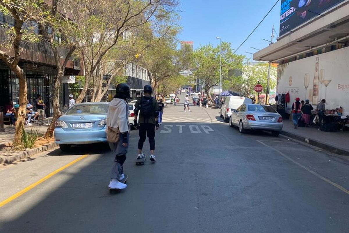 dva lidé jedoucí na skateboardech po městské ulici
