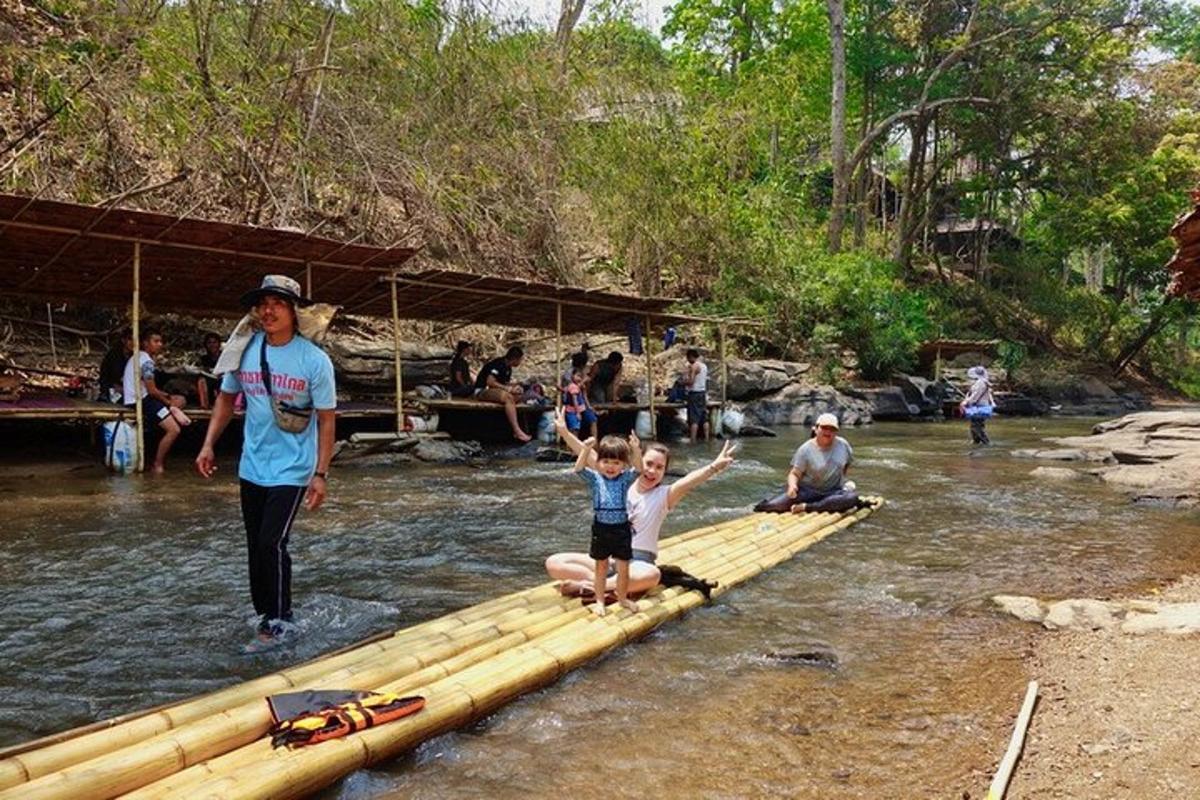 sekelompok orang menyeberangi jembatan bambu di sungai