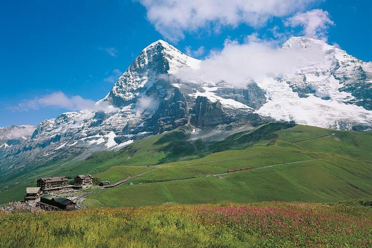 a snow covered mountain with a house in front of it