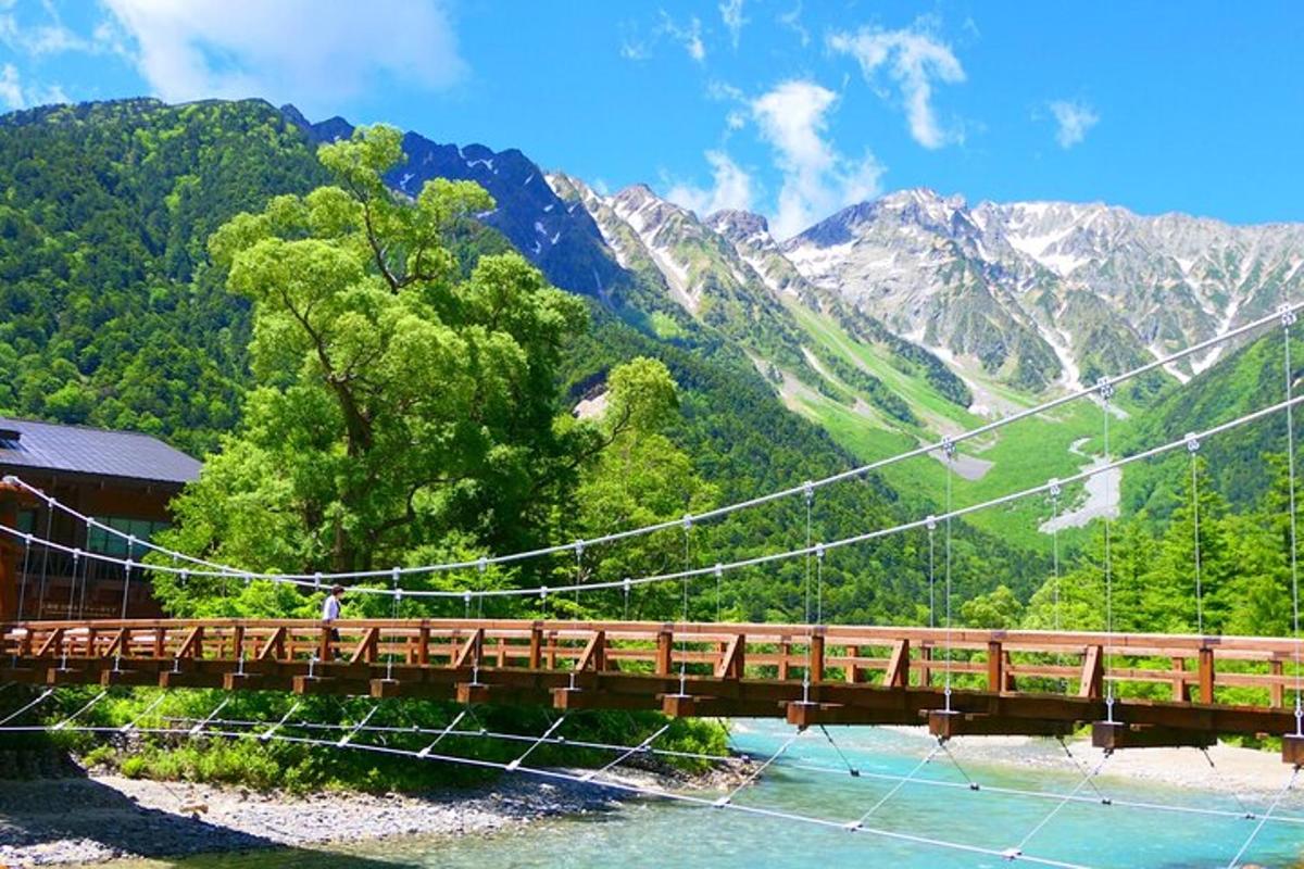 un pont sobre un riu amb muntanyes al fons