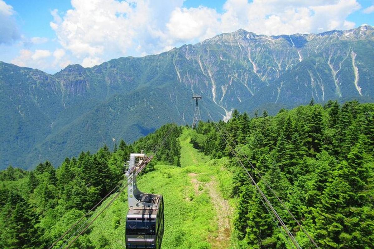 un treno che scende da una collina con le montagne sullo sfondo