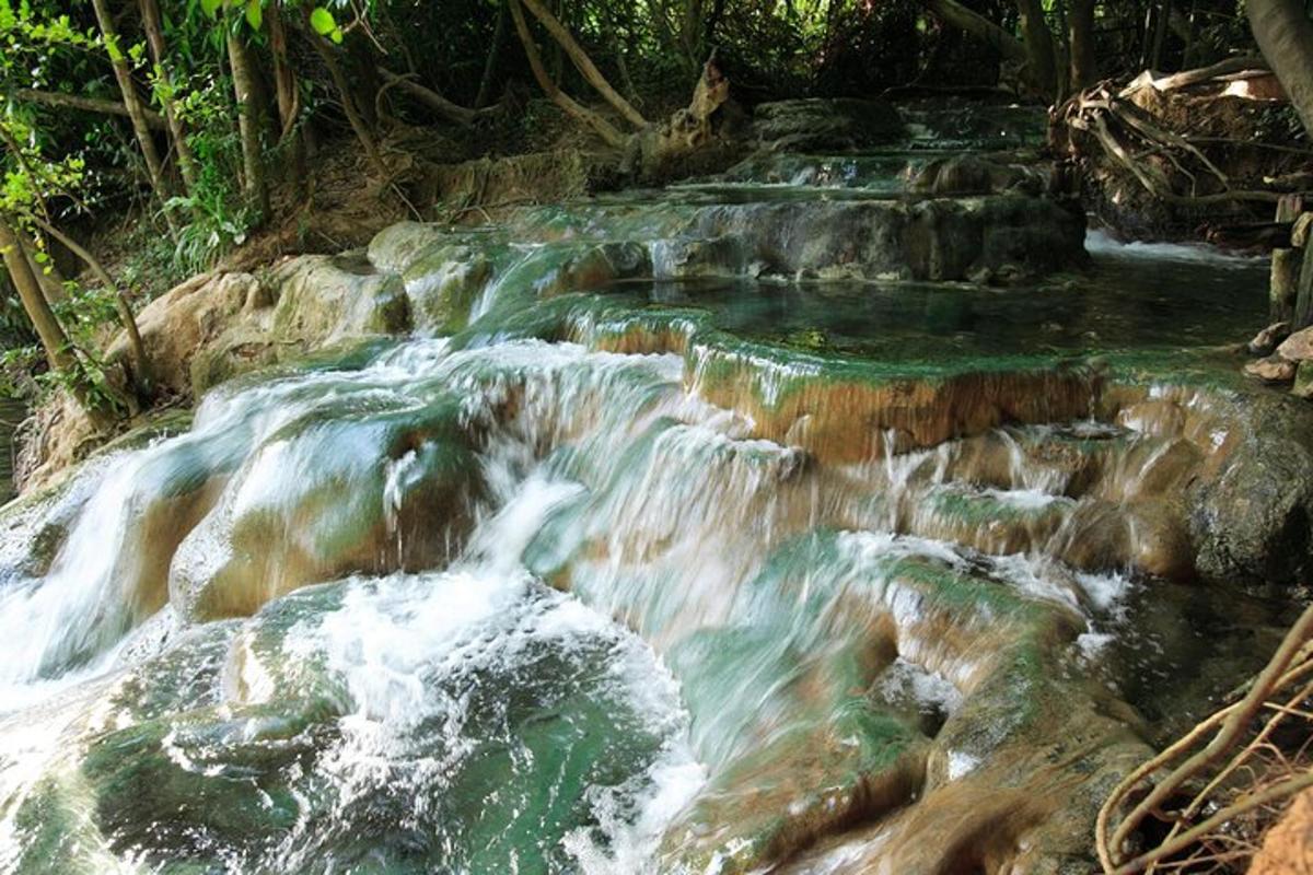un corrent d'aigua que corre sobre les roques en una cascada