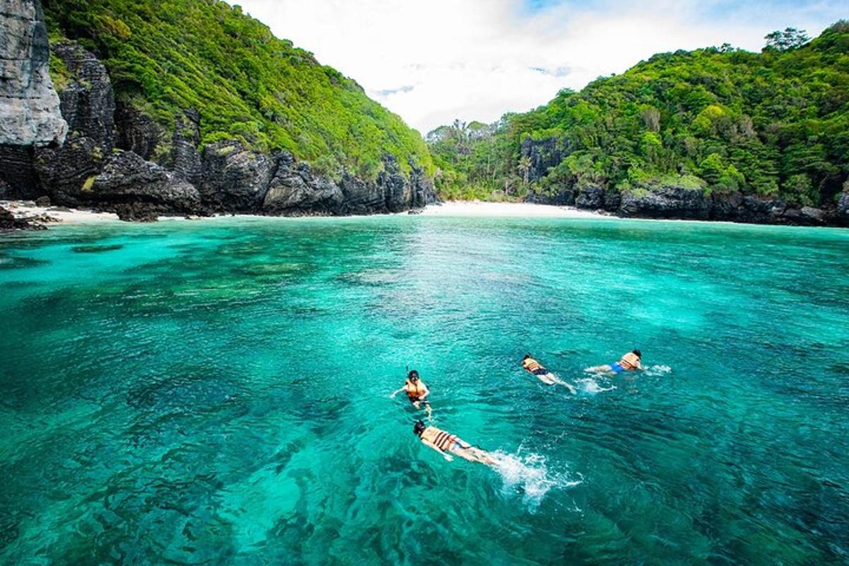 Tres personas nadando en el agua cerca de una playa