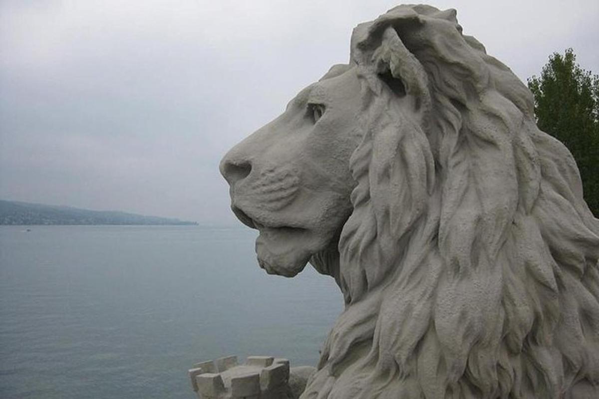 a statue of a lion is next to the water