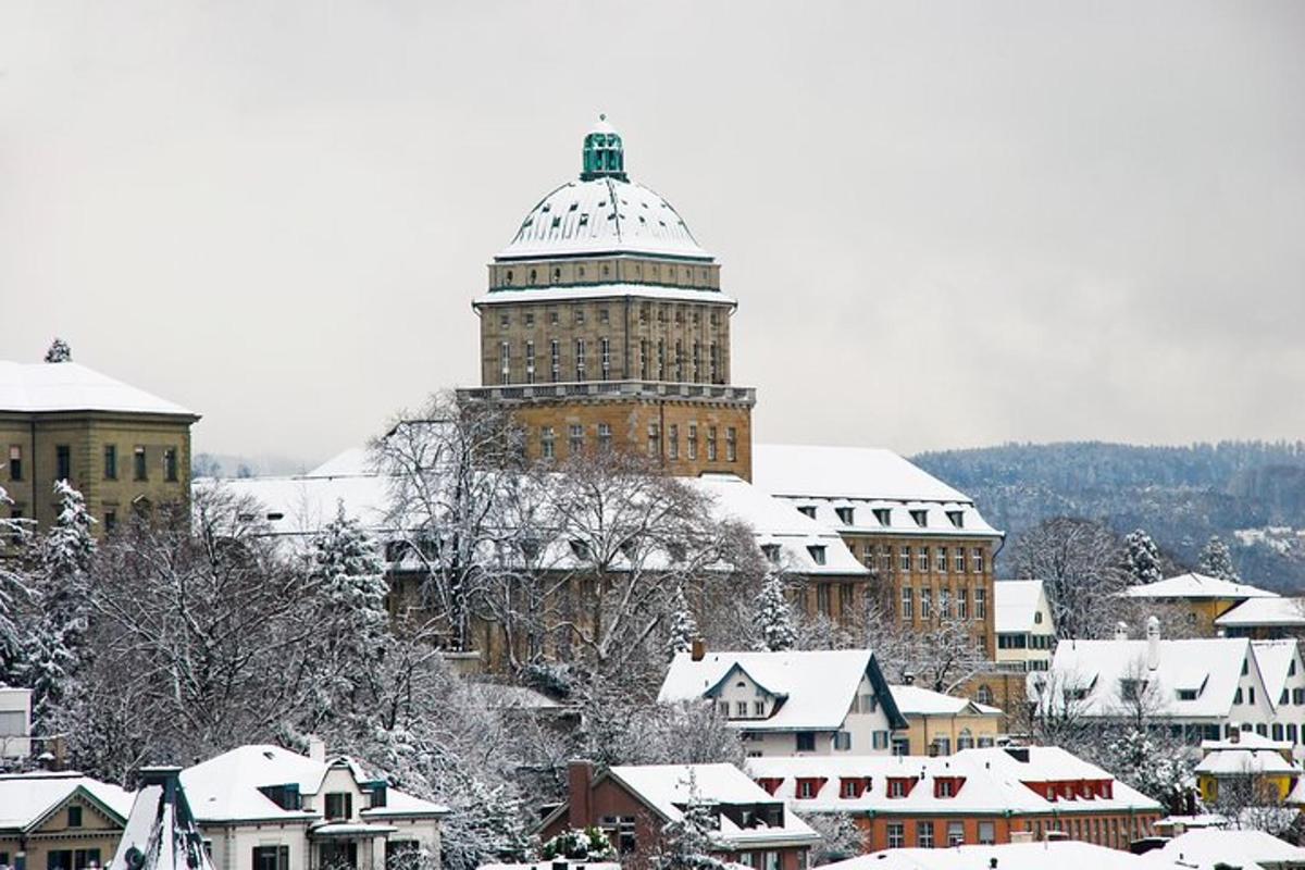 a snowy city with a clock tower in the background