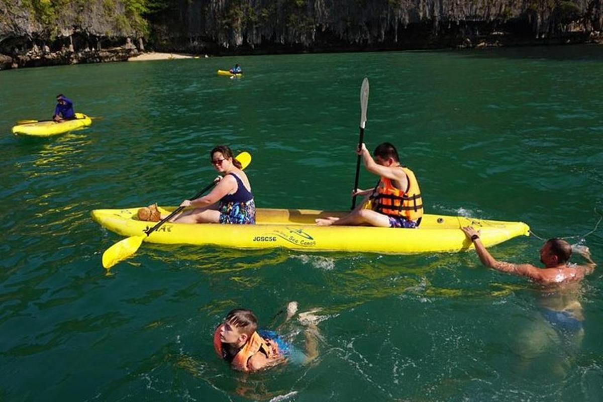 a group of people in a yellow kayak in the water