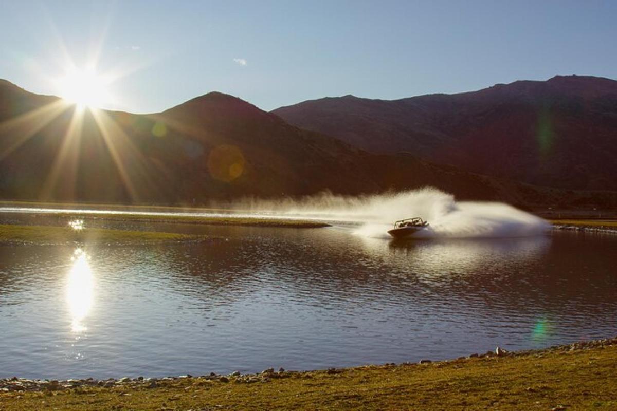 Un barco en el agua con el sol detrás.