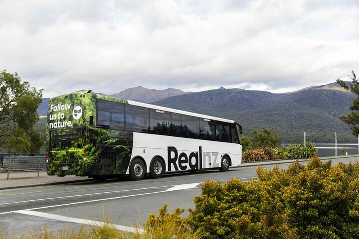 un autobus che percorre una strada con le montagne sullo sfondo