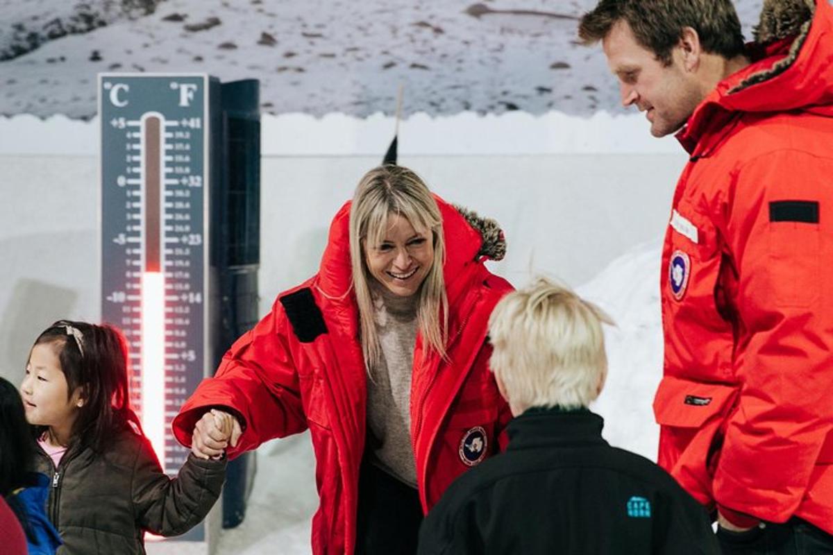 a woman in a red jacket talking to a group of people