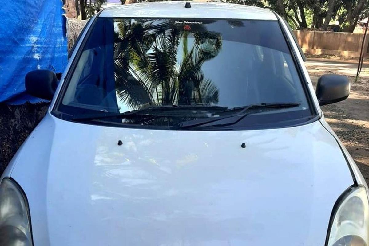 un'auto bianca con il riflesso di una palma