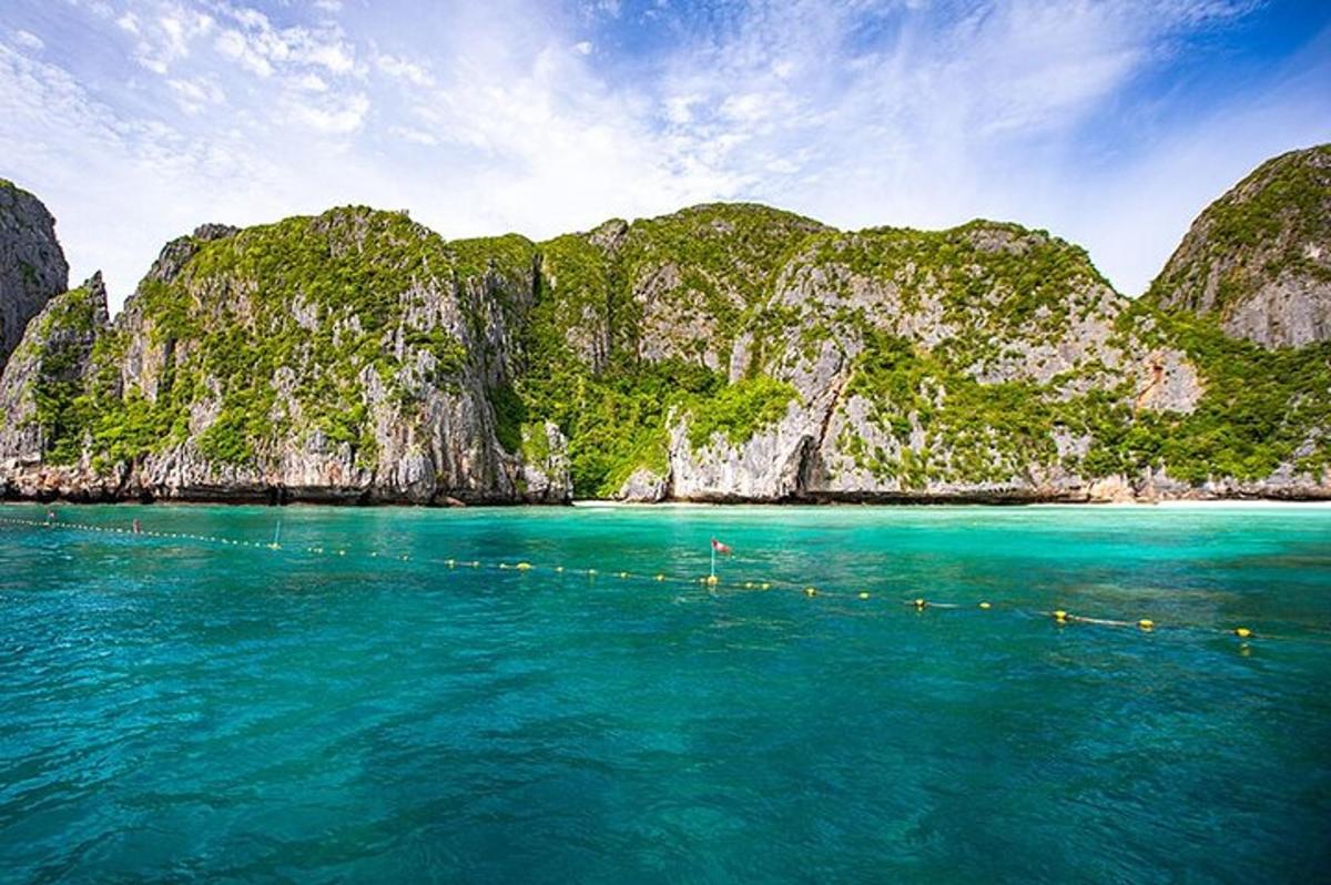 una barca in acqua vicino a un'isola rocciosa