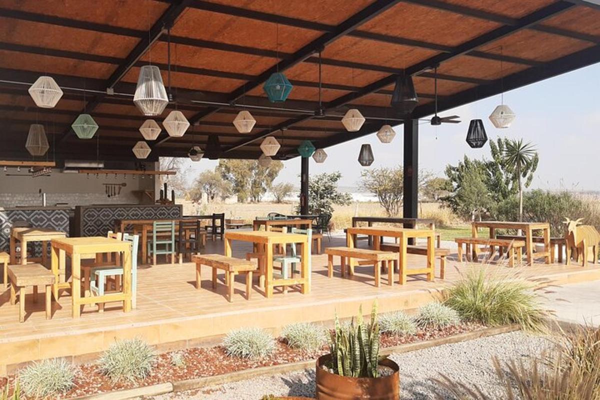 un patio con tavoli e sedie in legno e luci